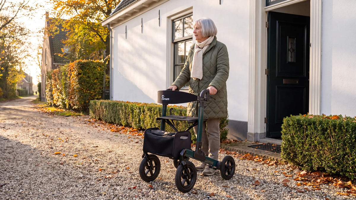 Parvum Luxo Air in petrolgroen op een grindpad voor een wit huis; een vrouw staat even stil en kijkt naar de weg.