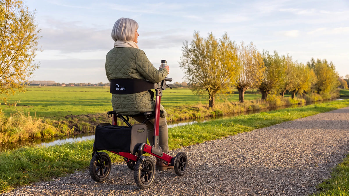 Parvum Luxo Air in robijnrood langs een polderslootje; een vrouw zit op de rollator met een kop thee.