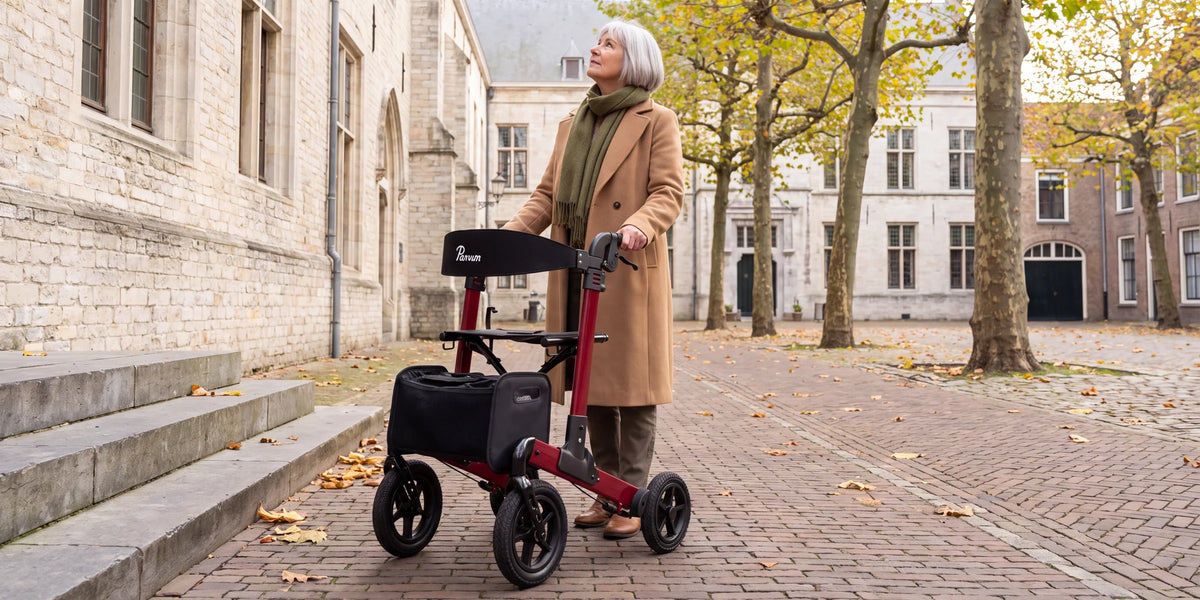 Parvum Luxo Air in robijnrood op een plein met platanen en oude stenen gebouwen; een vrouw kijkt omhoog.