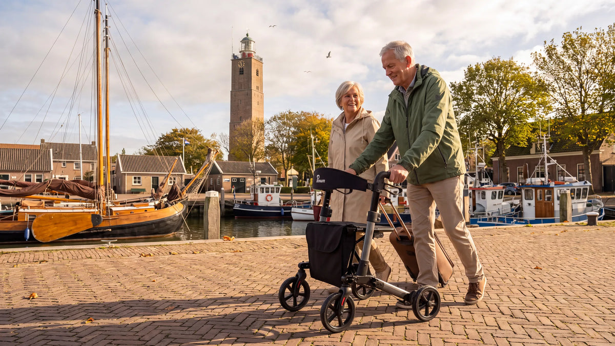 Parvum Brava in anthracite on a harbor quay; a man pushes the rollator, his wife walking beside him.