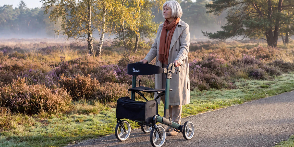 Parvum Luxo in petrol green on a heath path in the morning mist; a woman stops for a moment and looks out over the heath.