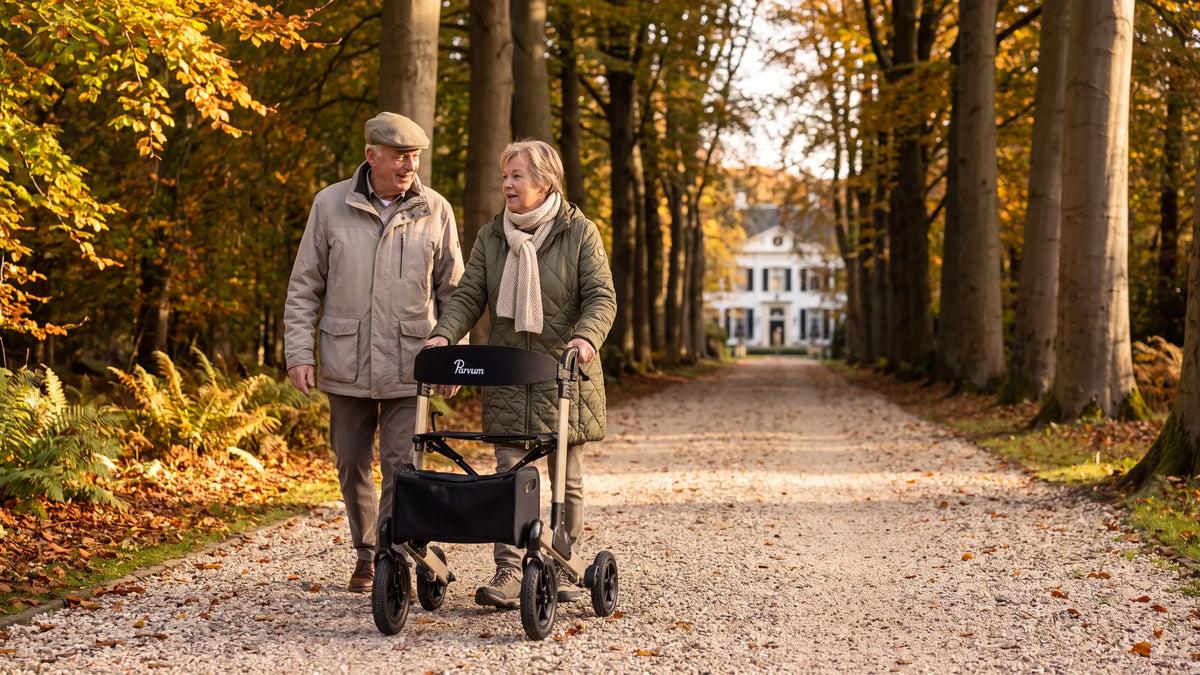 Parvum Luxo Air in champagne in een beukenlaan; een vrouw duwt de rollator, haar man loopt naast haar.